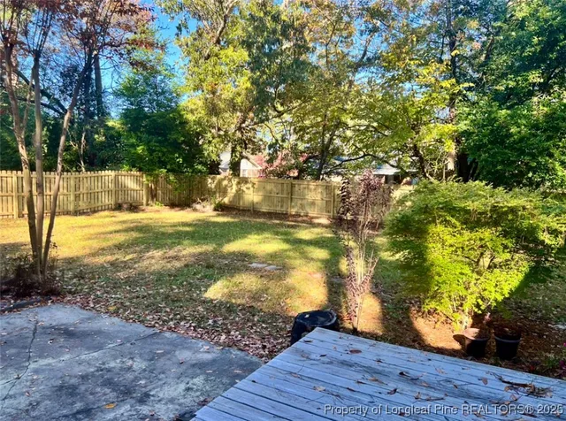 a view of a yard with wooden fence