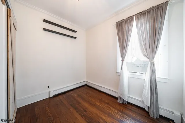 an empty room with wooden floor and a window
