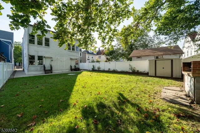 a view of a yard with a house and a large tree