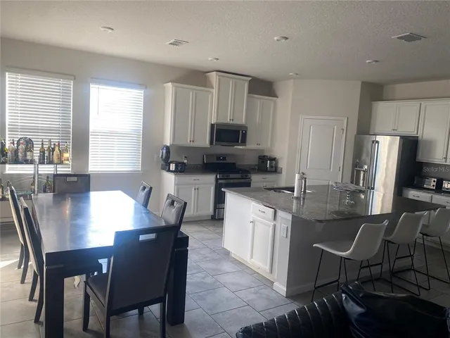a kitchen with granite countertop a dining table and chairs