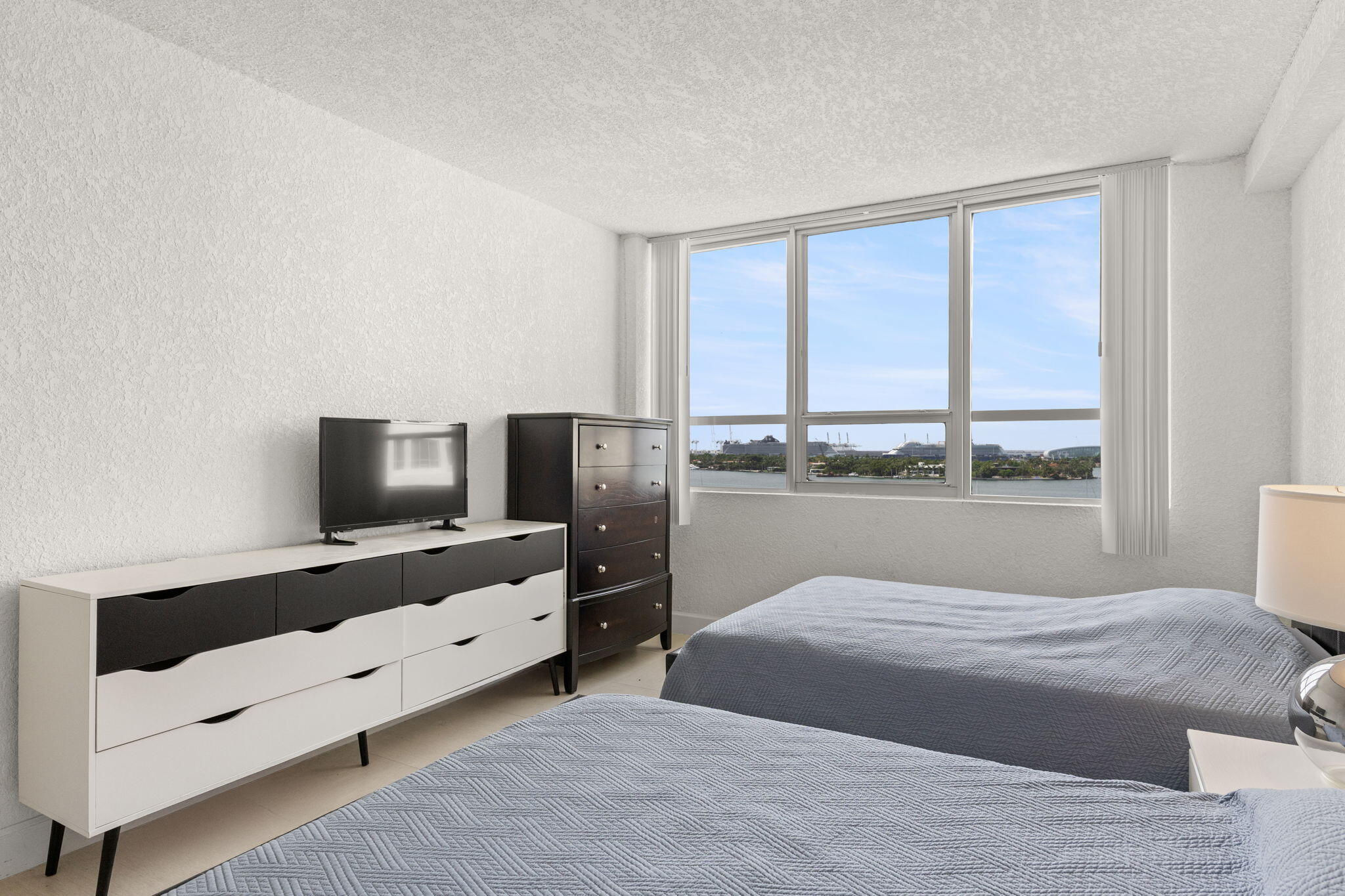 1500 Bay Road, Unit 1122S Miami Beach, FL 33139 - Photo 14 of 24 a bedroom with a large bed and a flat tv screen on dresser