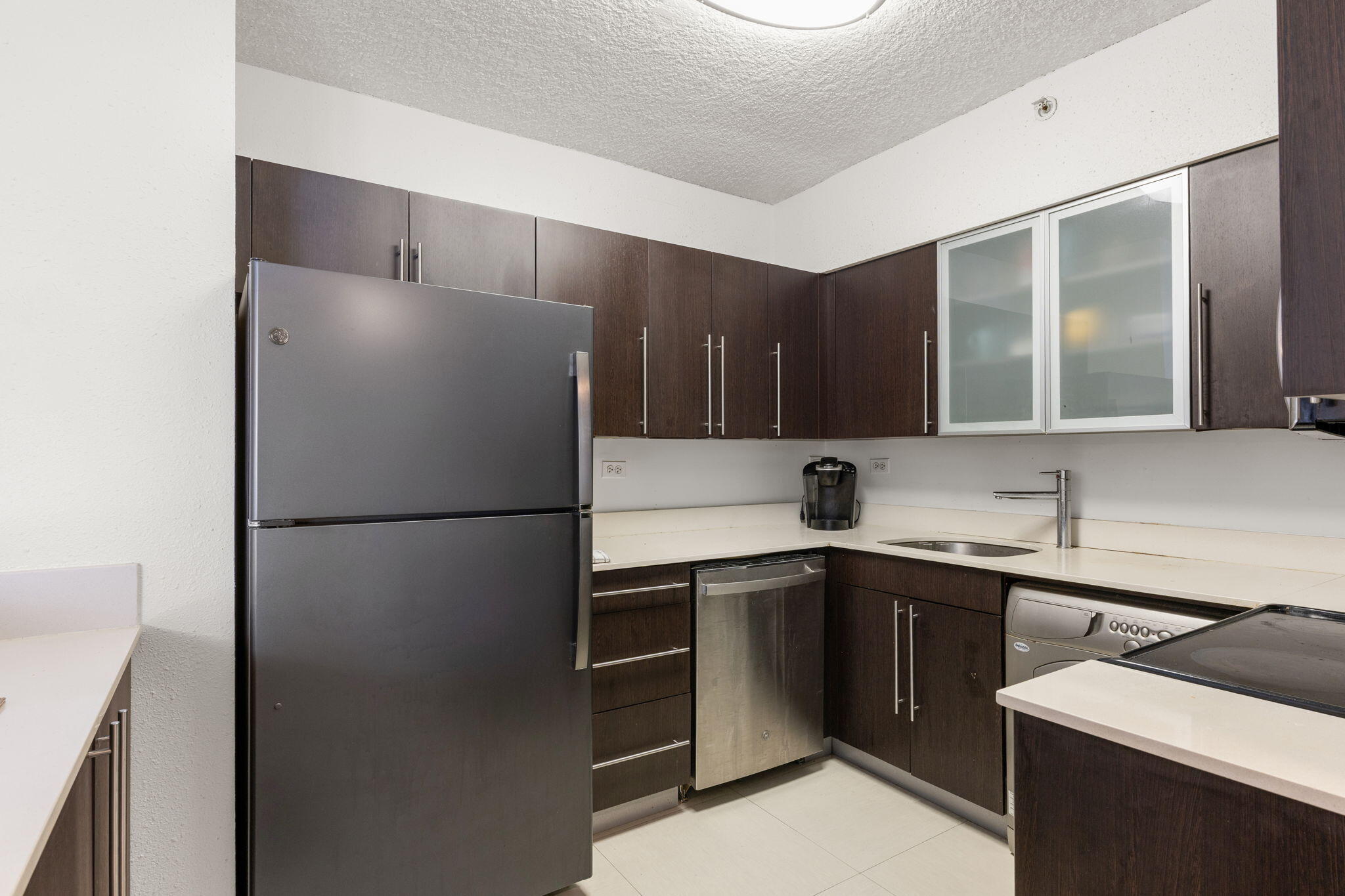 1500 Bay Road, Unit 1122S Miami Beach, FL 33139 - Photo 6 of 24 a kitchen with a sink a refrigerator and cabinets
