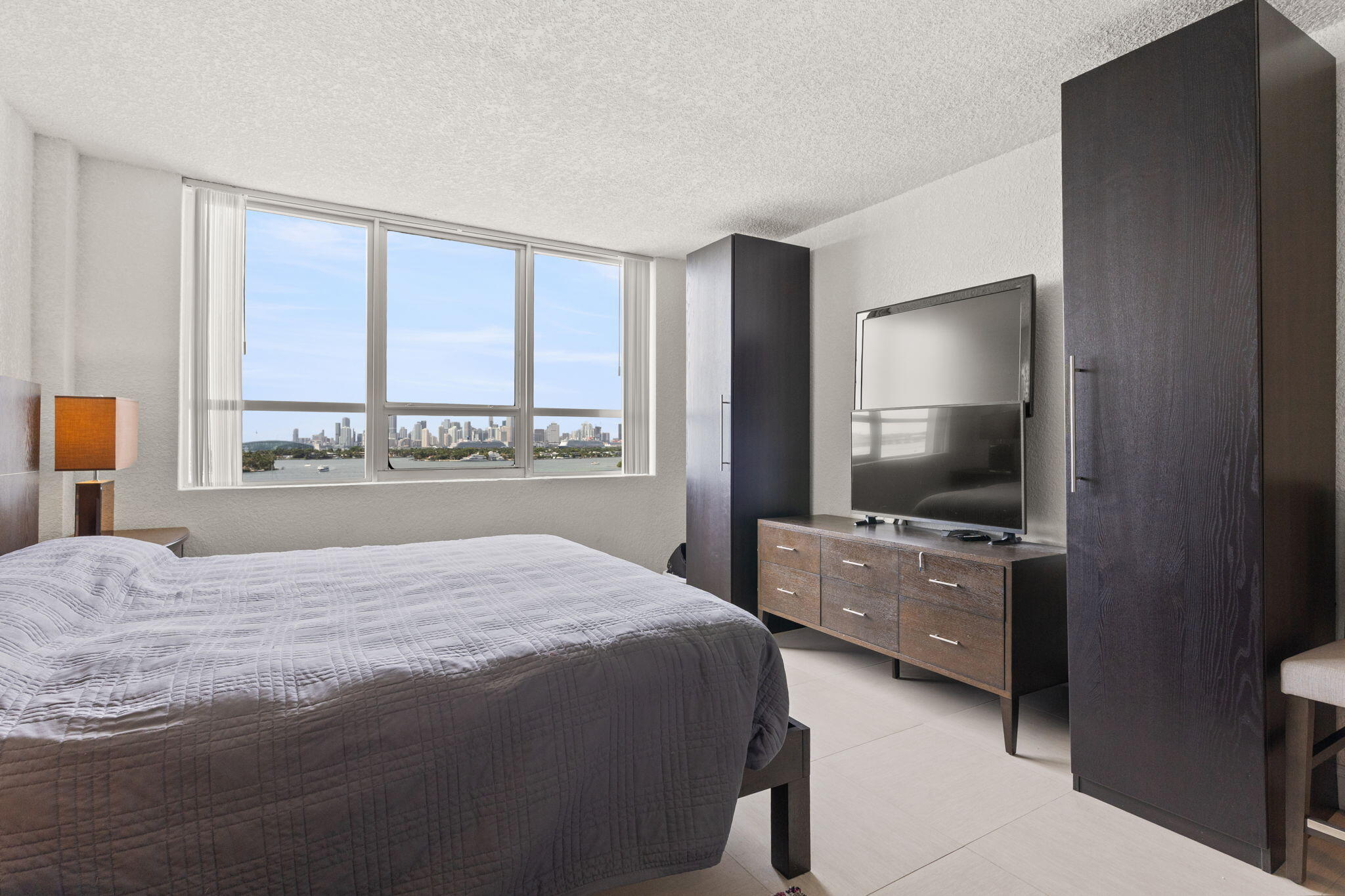 1500 Bay Road, Unit 1122S Miami Beach, FL 33139 - Photo 8 of 24 a bedroom with a bed and a flat tv screen on dresser