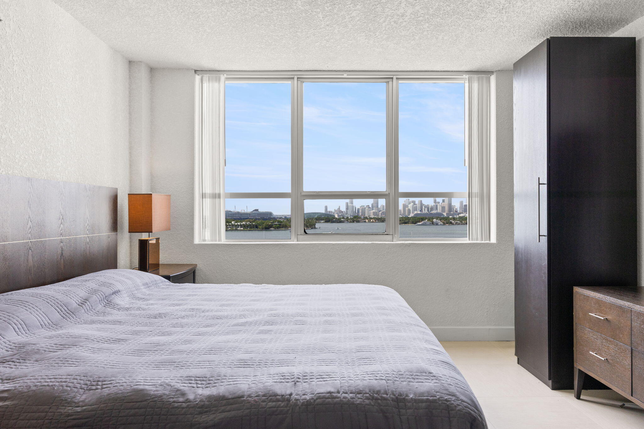 1500 Bay Road, Unit 1122S Miami Beach, FL 33139 - Photo 9 of 24 a bedroom with a bed and a large window