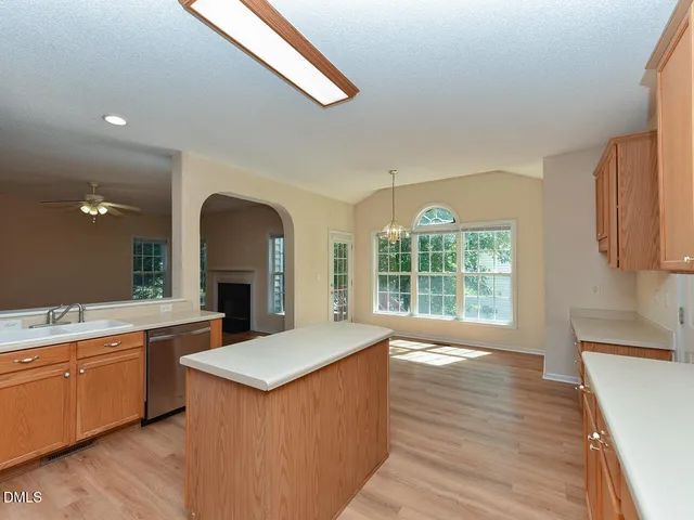a large kitchen with stainless steel appliances granite countertop a white cabinets and wooden floor