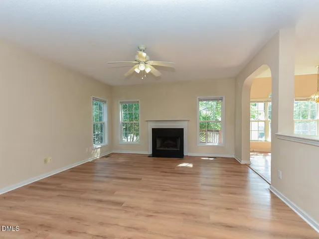wooden floor fireplace and windows in an empty room