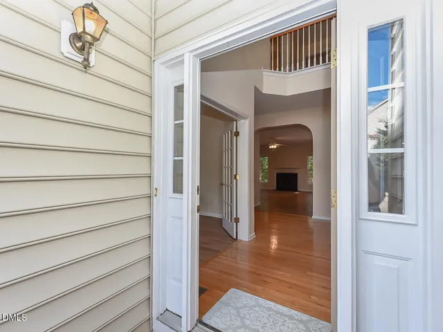a view of a hallway with wooden floor and dining room
