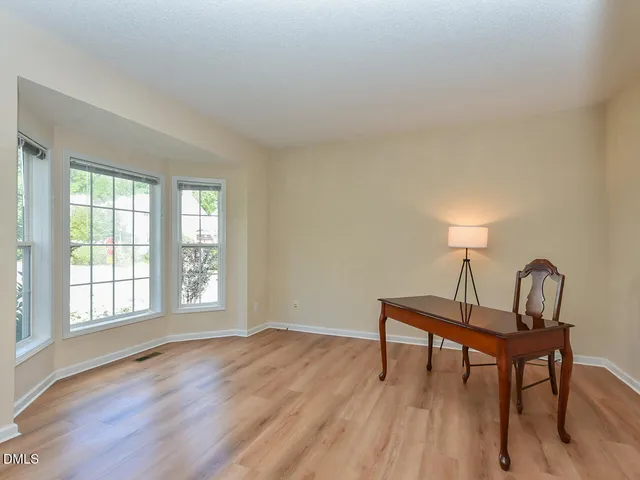 a workspace room with furniture and window