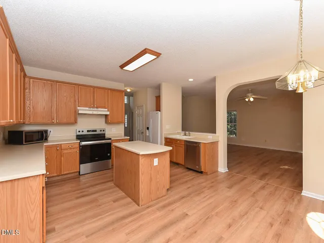 a kitchen with a refrigerator and a stove top oven