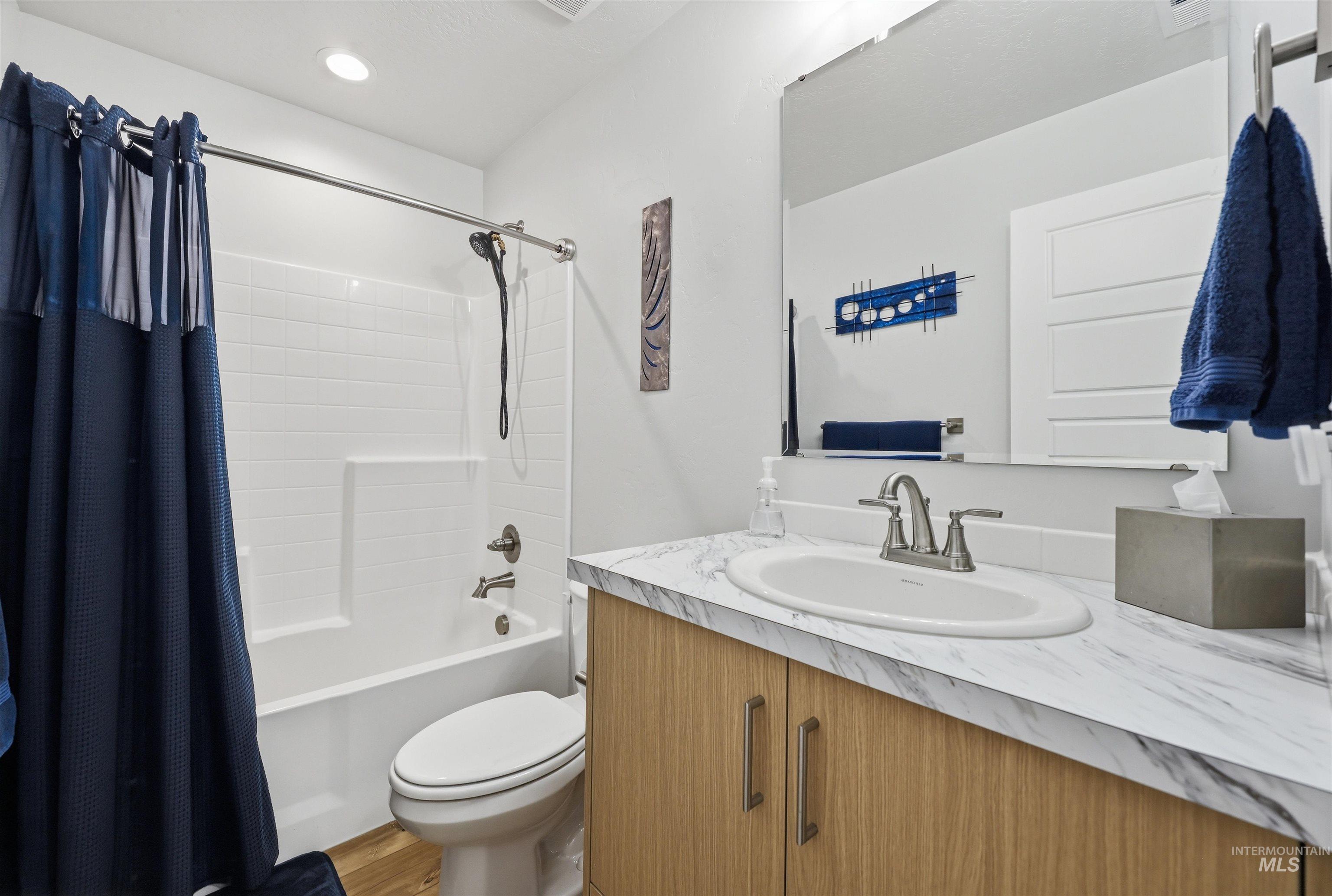 3811 West Maypearl Street Meridian, ID 83642 - Photo 8 of 39 Bathroom featuring a wood-finish vanity with a marbled countertop, an undermount sink, and brushed nickel fixtures