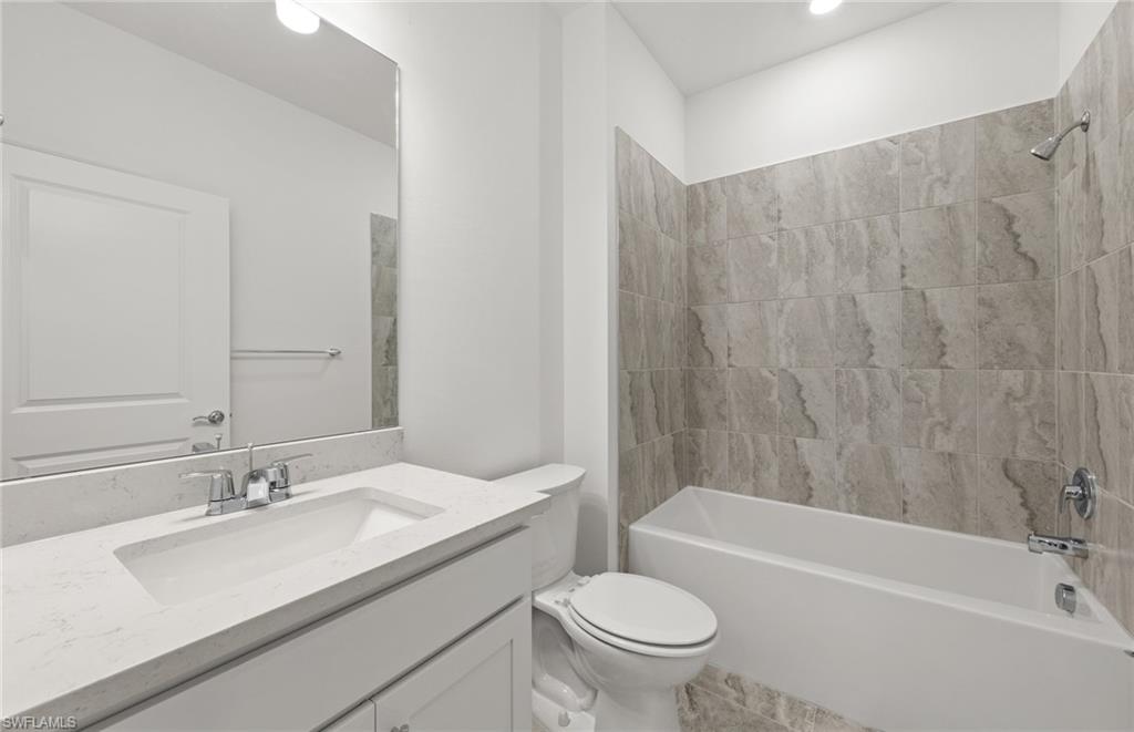 3922 East Hampton Circle Fort Myers, FL 33905 - Photo 20 of 24 a bathroom with a granite countertop sink toilet and bathtub