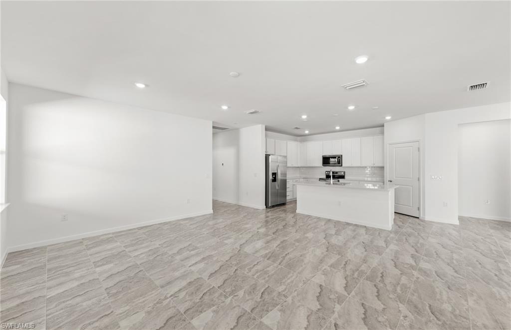 3922 East Hampton Circle Fort Myers, FL 33905 - Photo 3 of 24 a view of large kitchen with white cabinets and stainless steel appliances