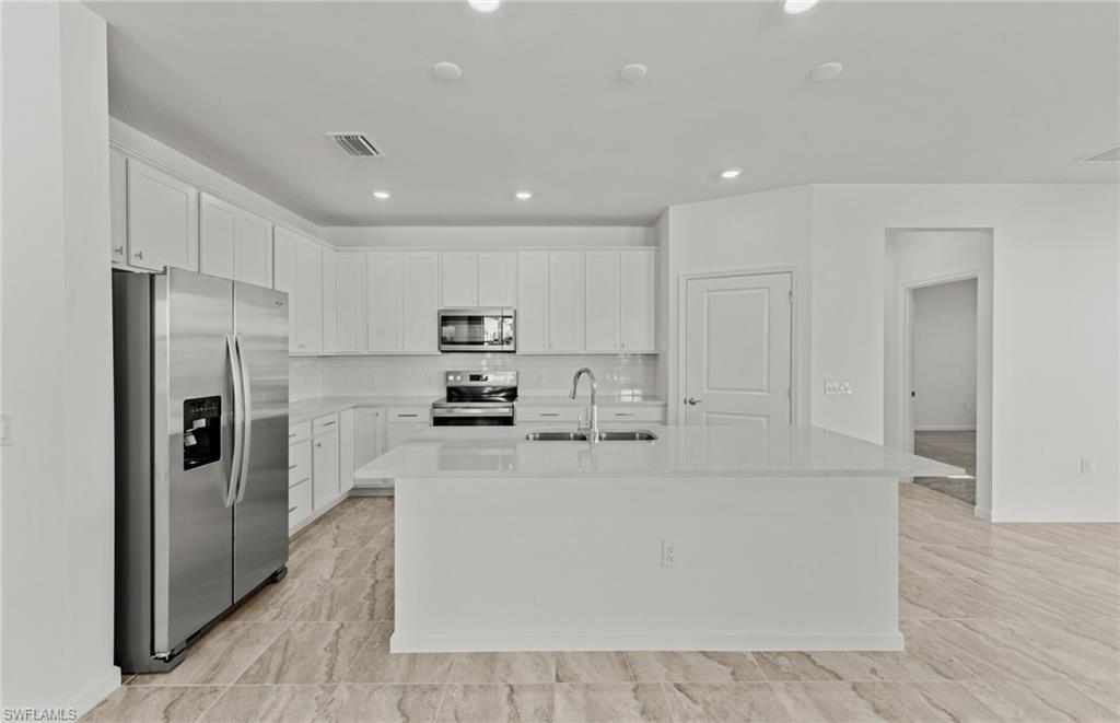 3922 East Hampton Circle Fort Myers, FL 33905 - Photo 5 of 24 a large white kitchen with stainless steel appliances