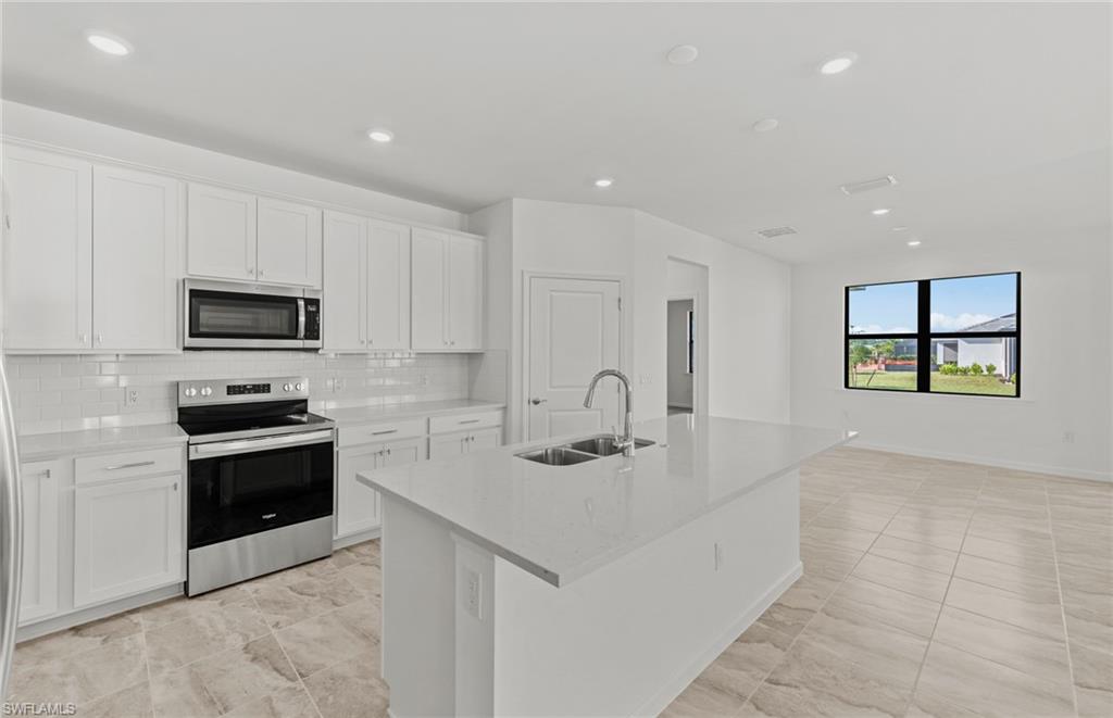 3922 East Hampton Circle Fort Myers, FL 33905 - Photo 6 of 24 a kitchen with stainless steel appliances a stove a sink a microwave a refrigerator and cabinets