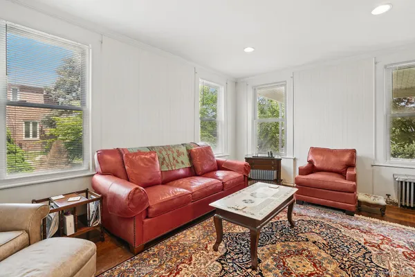 a living room with furniture a rug and a window