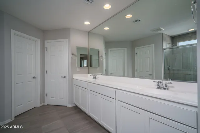 a bedroom with a large bed and a ceiling fan