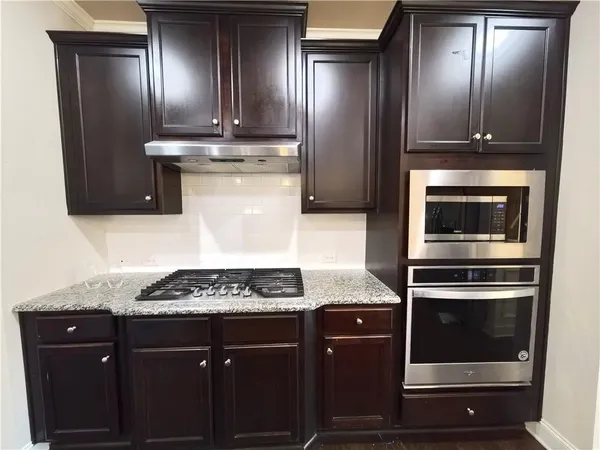 a kitchen with stainless steel appliances granite countertop a stove oven and a counter space