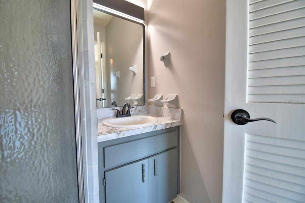 1920 East Edgewood Drive, Unit R8 Lakeland, FL 33803 - Photo 12 of 30 a bathroom with a granite countertop sink and a mirror