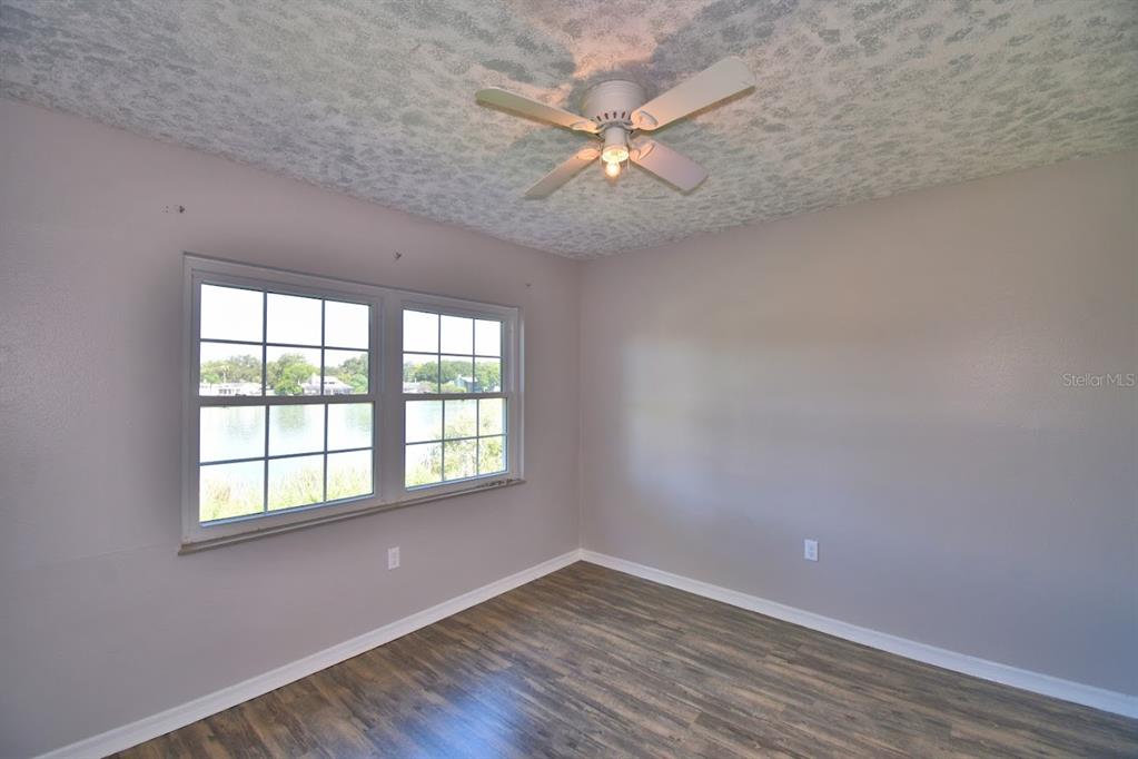 1920 East Edgewood Drive, Unit R8 Lakeland, FL 33803 - Photo 13 of 30 an empty room with wooden floor fan and windows
