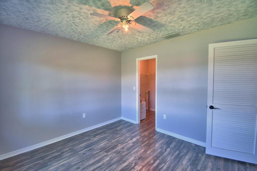 1920 East Edgewood Drive, Unit R8 Lakeland, FL 33803 - Photo 14 of 30 an empty room with a chandelier fan and wooden floor