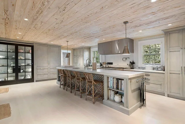 a kitchen with kitchen island a sink stove and cabinets