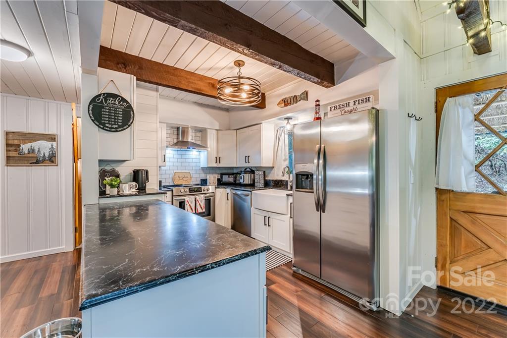 1305 Old Balsam Road Waynesville, NC 28786 - Photo 16 of 42 a kitchen with stainless steel appliances granite countertop a refrigerator a stove and a sink with granite countertops