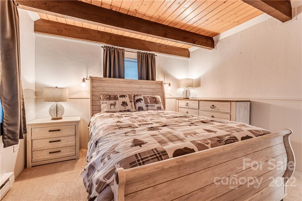 1305 Old Balsam Road Waynesville, NC 28786 - Photo 22 of 42 a bedroom with a bed and a cabinets