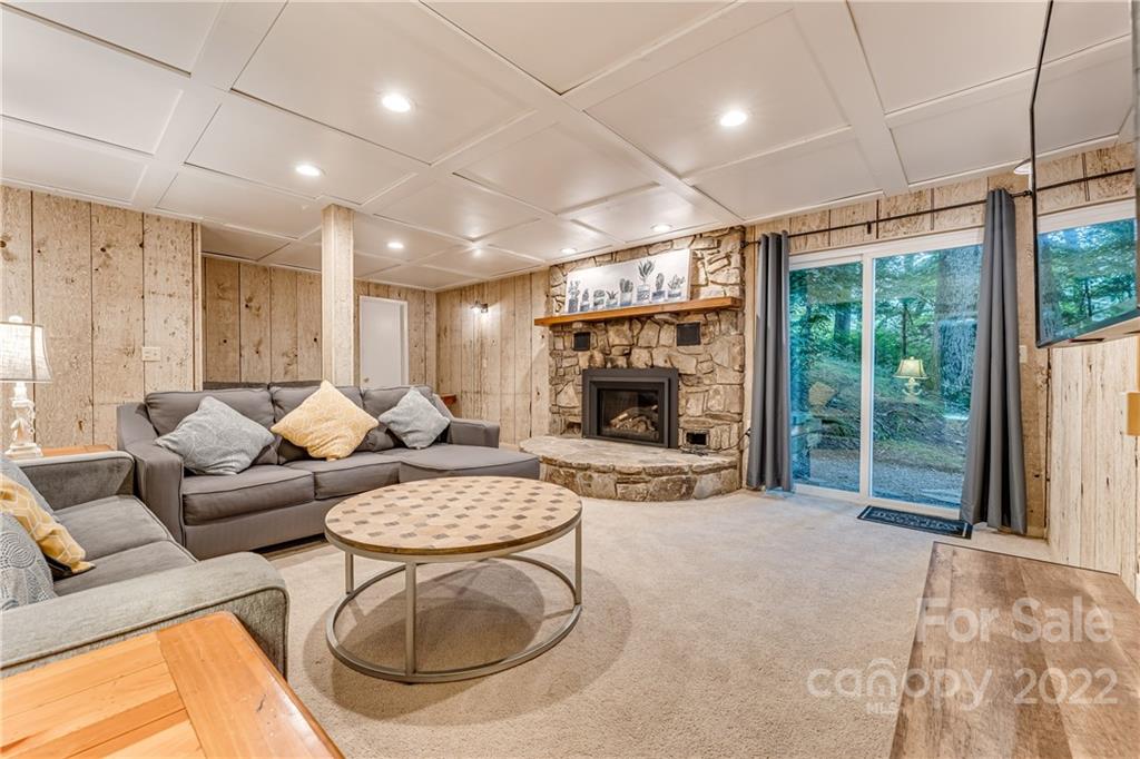 1305 Old Balsam Road Waynesville, NC 28786 - Photo 31 of 42 a living room with furniture a fireplace and a table