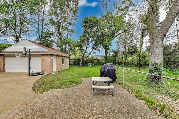 a view of a patio with a table chairs and a yard