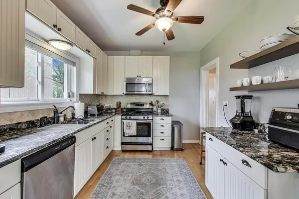 a kitchen with stainless steel appliances granite countertop a stove sink and cabinets
