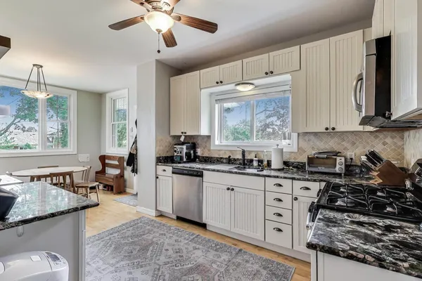 a kitchen with stainless steel appliances granite countertop a stove and cabinets