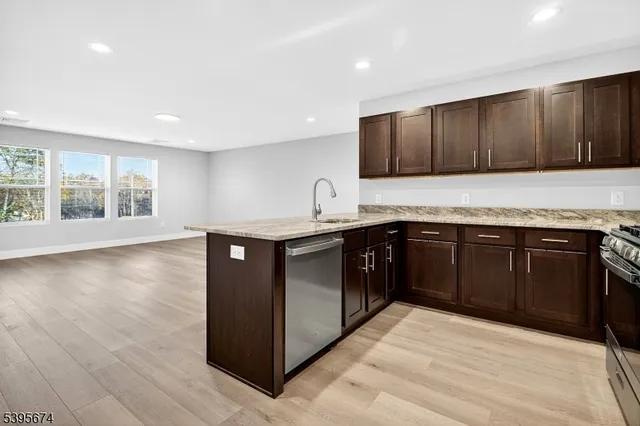 a kitchen with stainless steel appliances granite countertop a stove a sink and a microwave