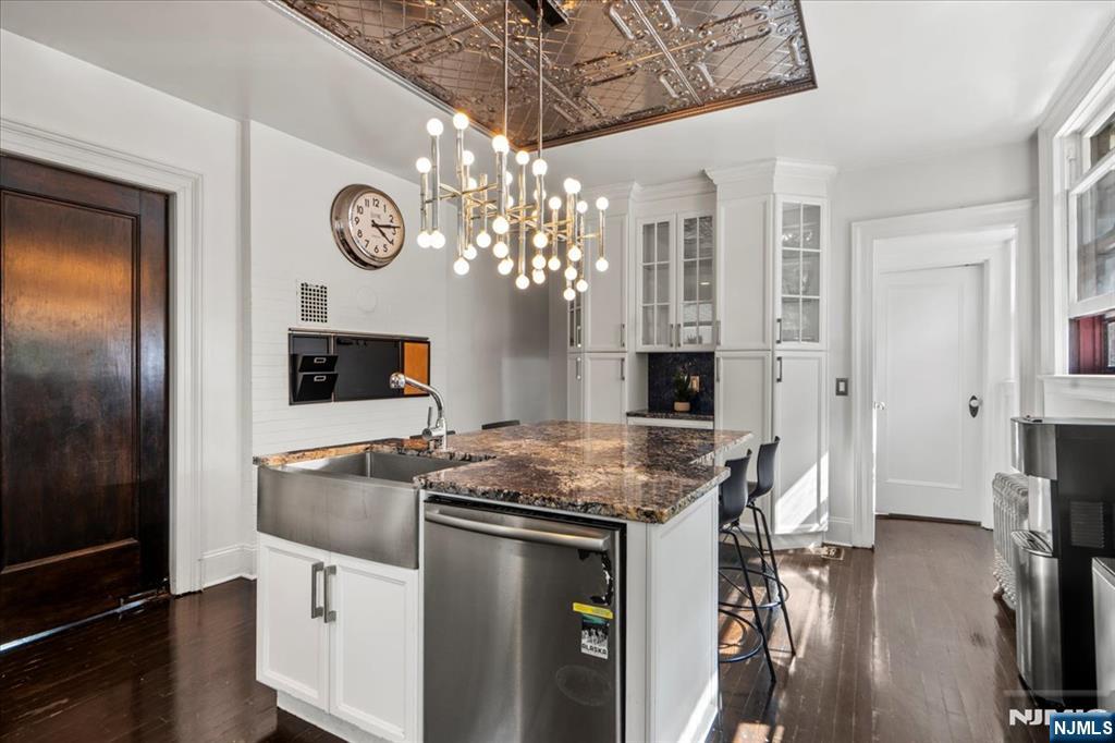 12 Harrison Avenue Montclair, NJ 07042 - Photo 2 of 34 a kitchen with stainless steel appliances granite countertop a stove top oven a refrigerator a oven with a dining table and chairs