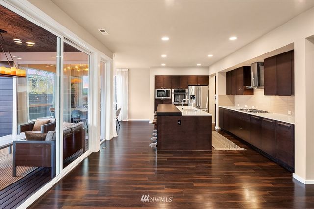 a large kitchen with kitchen island a sink table and chairs