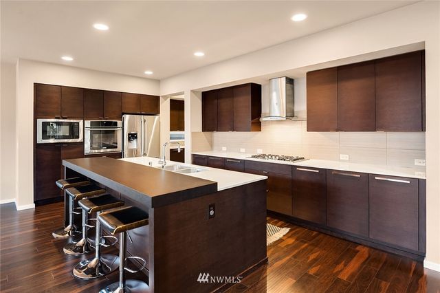 a living room with a flat screen tv and a view of kitchen