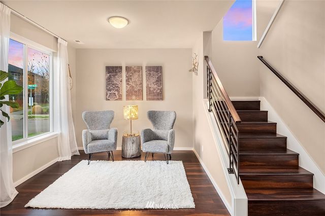a living room with furniture a rug and a painting