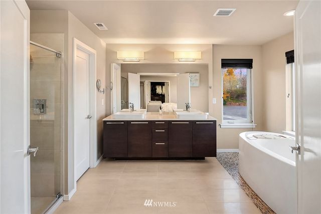a bathroom with a double vanity sink mirror and shower