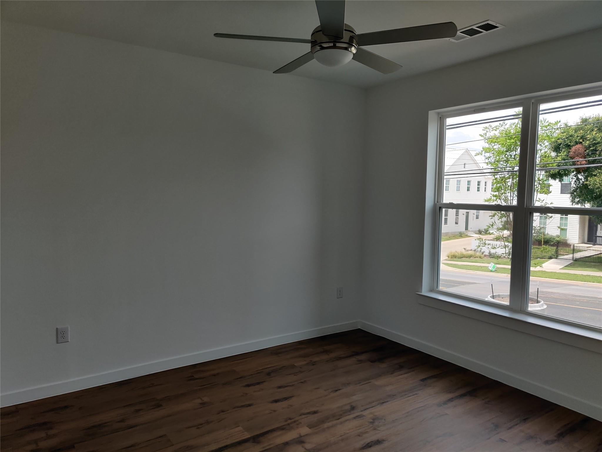 4801 Springdale Road, Unit 1102 Austin, TX 78723 - Photo 6 of 18 Rich wood-toned flooring and a large window frame pleasant neighborhood views.