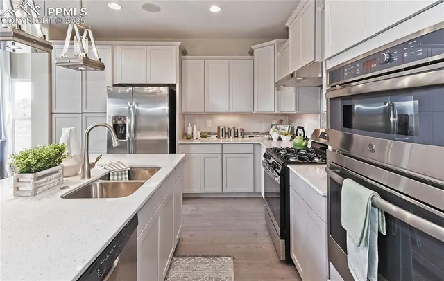 a kitchen with kitchen island granite countertop a sink stainless steel appliances and cabinets