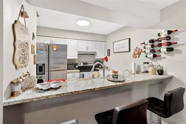 a kitchen with granite countertop white cabinets and stainless steel appliances