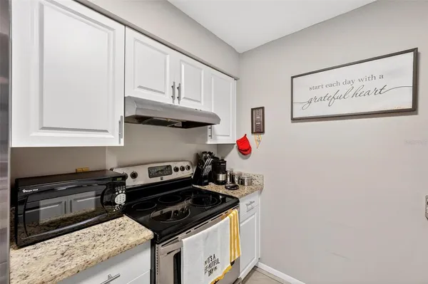 a kitchen with a sink a stove and a wooden floor