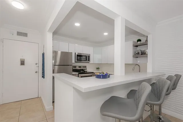 a kitchen that has a microwave a refrigerator and cabinets
