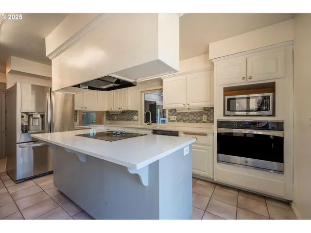 a kitchen with stainless steel appliances granite countertop a sink a stove and a refrigerator