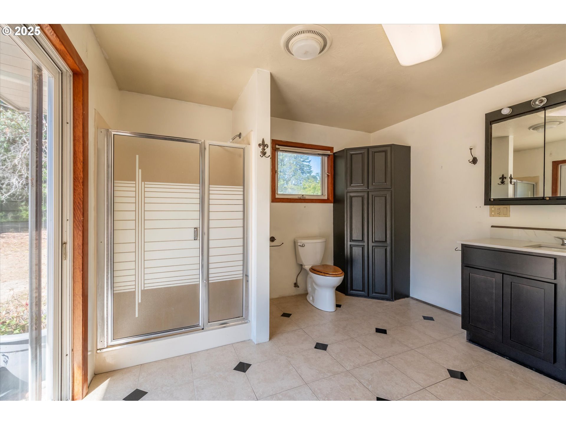 56060 Wheeler Road Bandon, OR 97411 - Photo 18 of 43 a bathroom with a sink a toilet a large mirror and shower