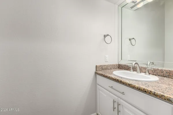 a bathroom with a granite countertop sink and a mirror