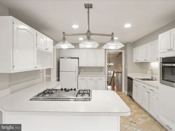a kitchen with kitchen island stainless steel appliances a sink stove and cabinets