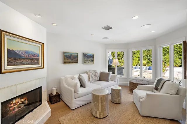a living room with fireplace furniture and a large window