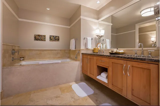 a bathroom with a tub sink and mirror