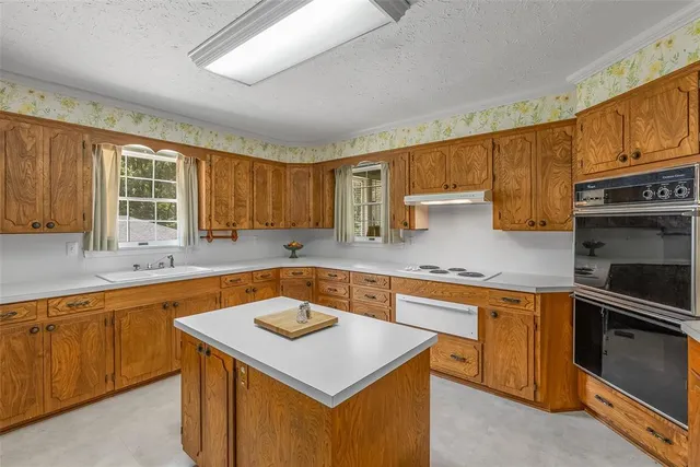 a kitchen with a sink stove top oven and cabinets