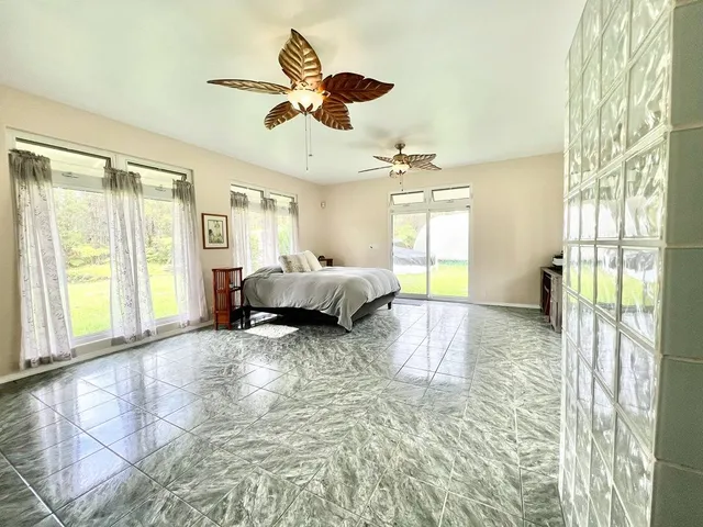 a bedroom with a bed and a large window